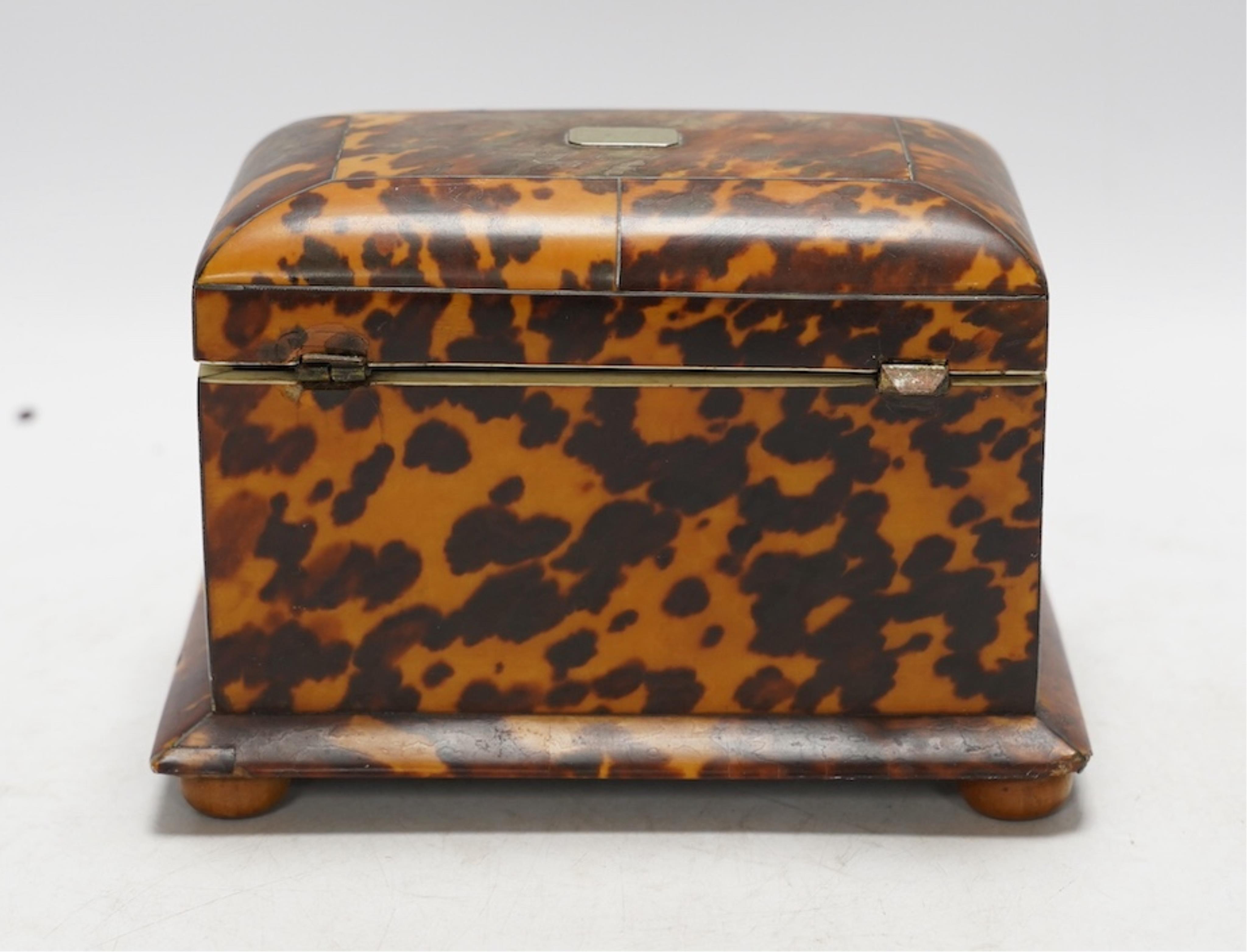 A Regency tortoiseshell tea caddy with inlaid silver and ivory stringing, on later bun feet, 12cm high. CITES Submission reference 64HKMP8J. Condition - poor to fair, lid detached, some repairs needed to stringing